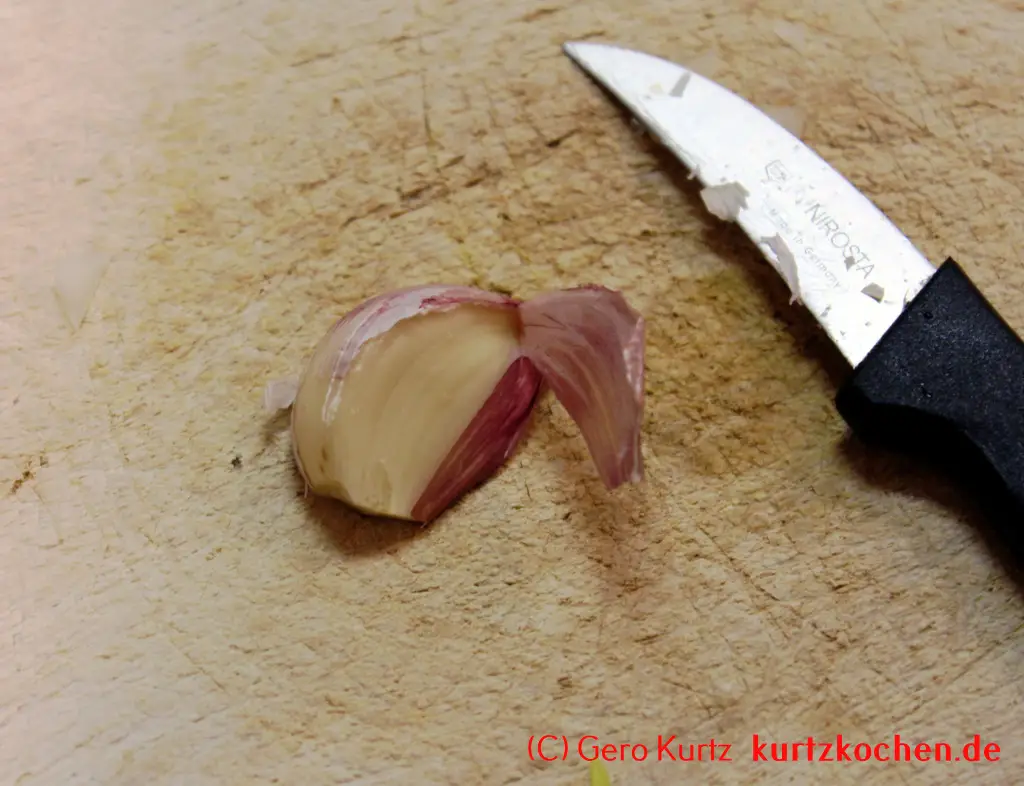 Rezept für Schweinerouladen - von der Knoblauchzehe mit einem Messer die Haut abziehen