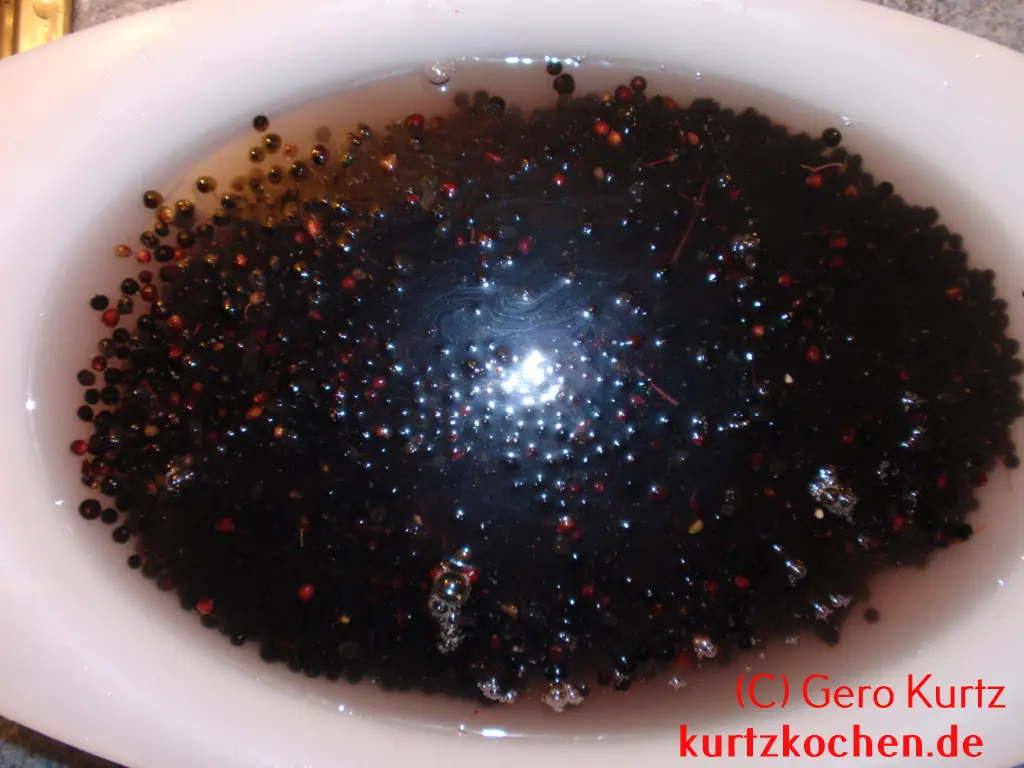Holundergelee - abgezupfte Holunderbeeren in einer Schüssel mit Wasser