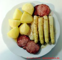 Spargel braune Butter mit Kartoffeln und Jagdwurstscheiben  auf einem Teller