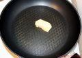 Rezept für schnellen Eierkuchen - ein Stück Butter in einer beschichteten Pfanne