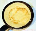 Rezept für schnellen Eierkuchen - gewendeter Eierkuchen in einer Pfanne aus Eisenguss