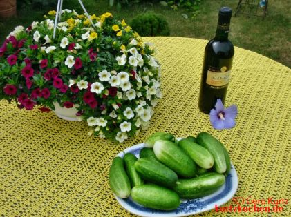 Teller mit Gurken auf einem Tisch mit Blumen und Wein